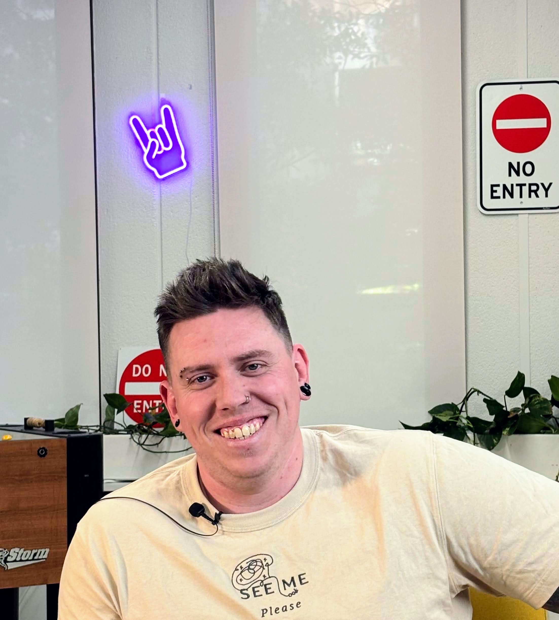 Photo of Dan smiling. he has two nose rings but  looks approachable and like a happy dude